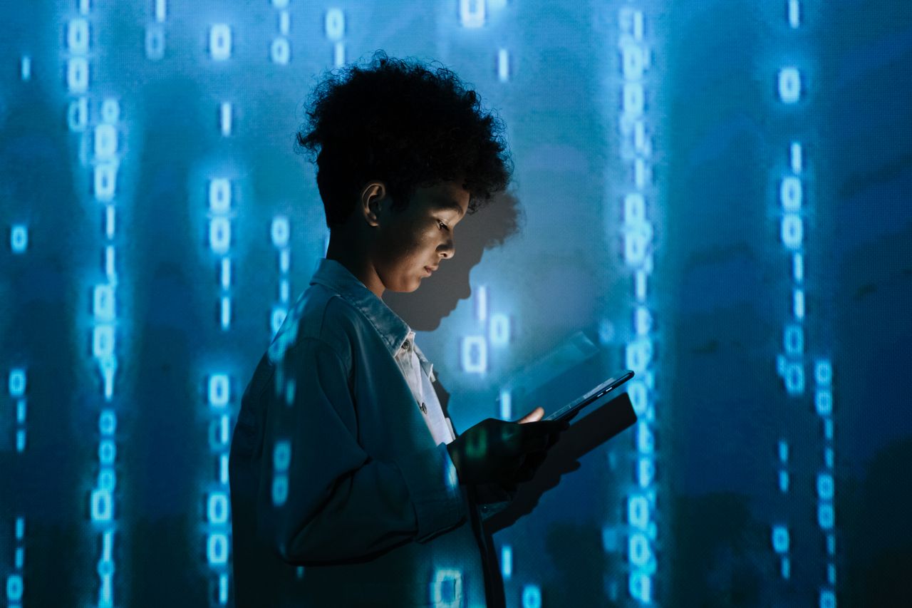 The Art of Drawing Readers In: Your attractive post title goes here Teenage boy with a tablet surrounded by digital binary code in a studio setting.